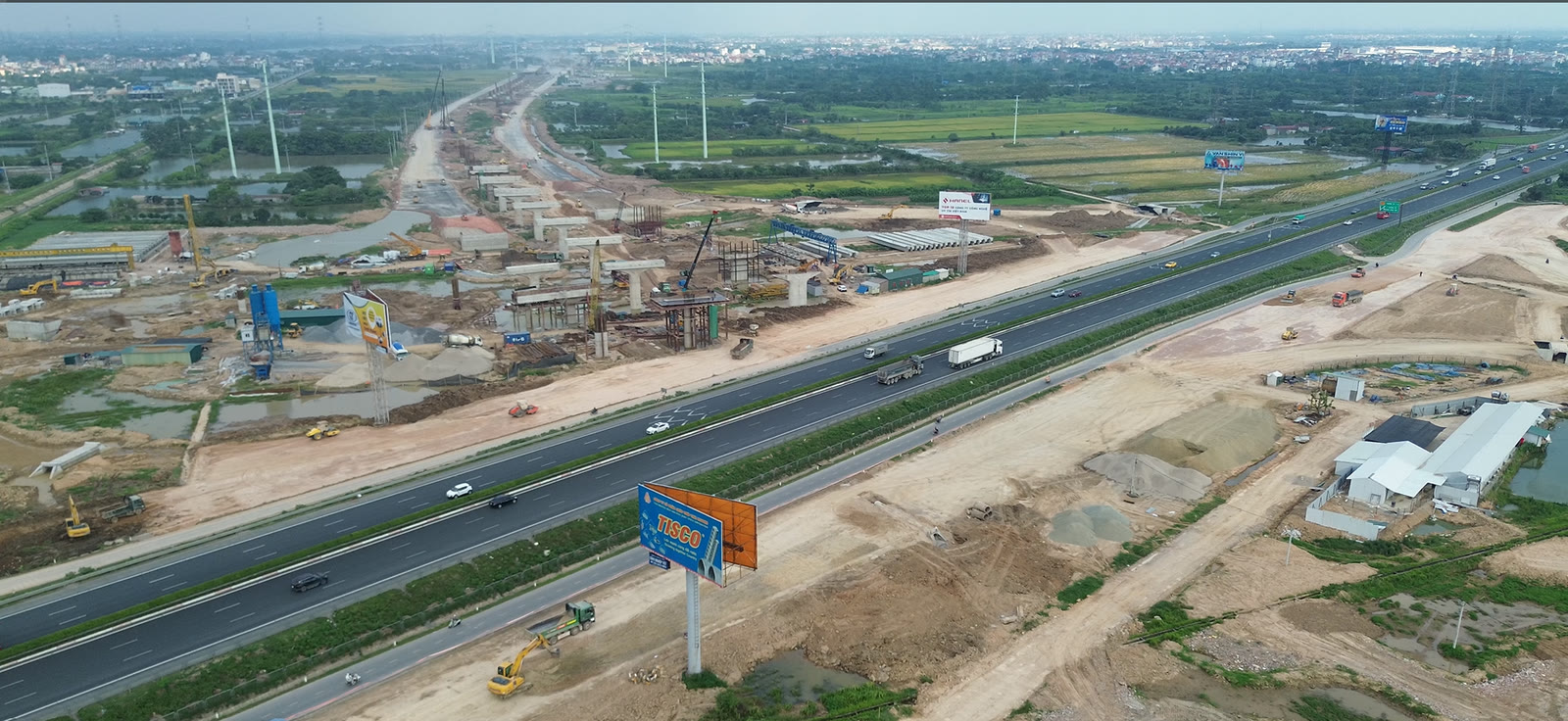 Đường dẫn và các trụ cầu cạn thuộc Vành đai 3,5 đang thi công chạy song song với tuyến cao tốc hiện hữu, nhìn từ trên cao