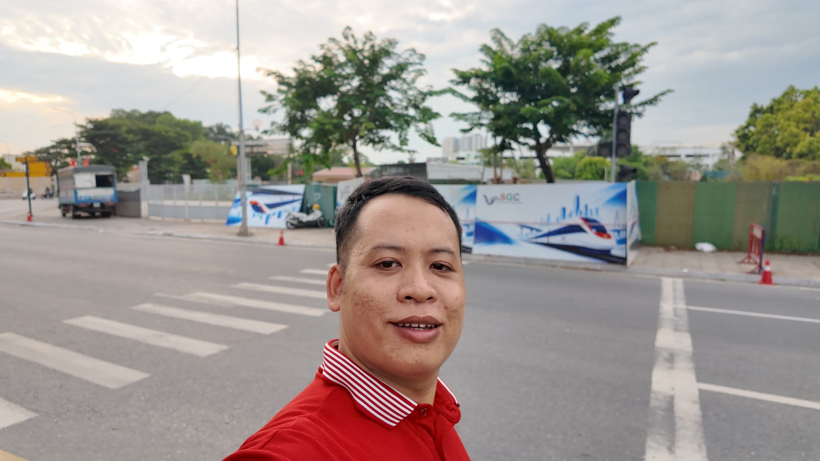 Phạm Tiến Lợi đứng bên đường Lý Thánh Tông khu vực Ocean Park 1, phía sau là khu đất đã quây rào tôn in phối cảnh tàu metro