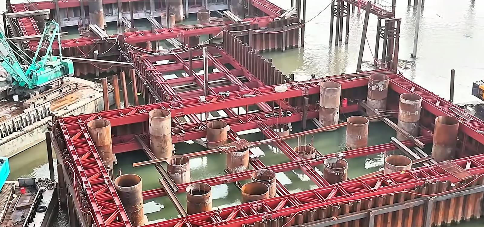 Vòng vây thép giữa sông Hồng tại trụ tháp cầu Ngọc Hồi, các ống vách cọc khoan nhồi nhô lên khỏi mặt nước bên trong hệ khung thép đỏ
